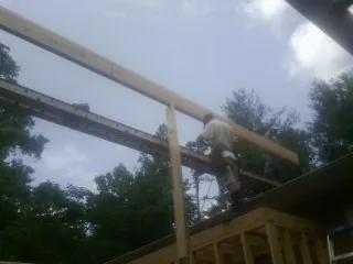 Carpenter setting a ridge beam over a new addition frame — Ice Dam Removal by Roofing Brothers in Binghamton