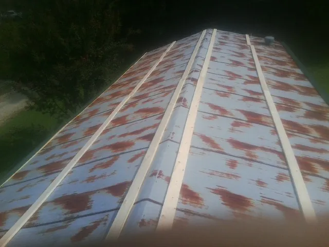Rusted metal roof panels with new wood purlins before replacement — Storm Damage Roof Repair in Binghamton by Roofing Brothers