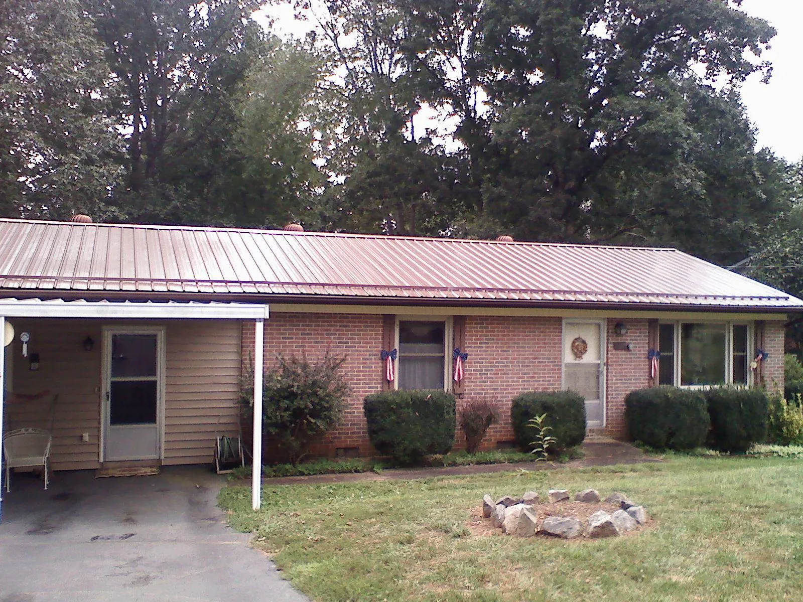Bronze metal roof and carport on a brick ranch home — Roof Repair work by our crew in Binghamton
